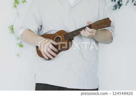 A man playing an ukulele A man playing an ukulele 124549920