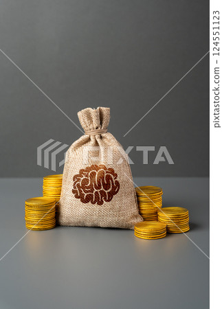 A bag with a brain symbol and money coins. Hunt for best minds and competition between leading powers for skilled specialists professionals. Attract top talent in science, technology, and innovation. 124551123
