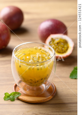 Glass of passion fruit juice with fresh passion fruit on wooden background, Healthy drink Glass of passion fruit juice with fresh passion fruit on wooden background, Healthy drink 124551421