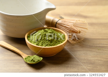 Matcha green tea powder with tea bowl and chasen on wooden background Matcha green tea powder with tea bowl and chasen on wooden background 124551427