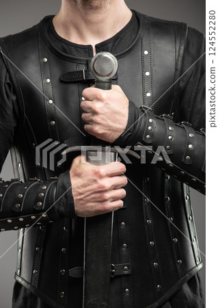 Person Wearing Black Widow Leather Bracers Holding Sword 124552280