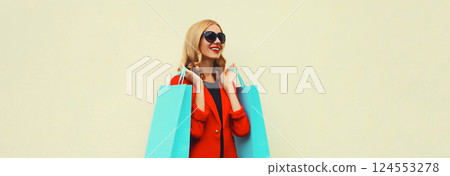 Fashion, purchase. Stylish happy woman with shopping bags, beautiful girl in red business suit 124553278