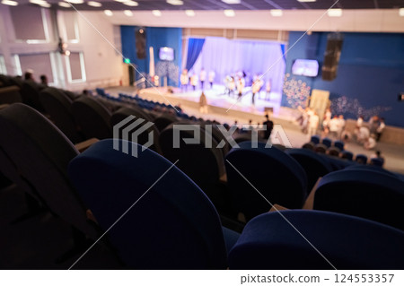 The rehearsal of the play. People in the auditorium are watching the performance. A music concert or festival. Out of focus. High quality photo 124553357