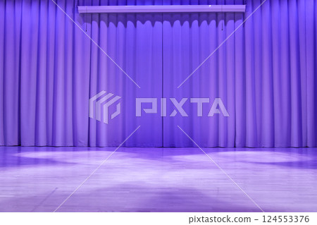 A stage with a platform in the form of a podium with trendy purple lighting. Fabric wavy background with space for copying. An element for your design. High quality photo 124553376