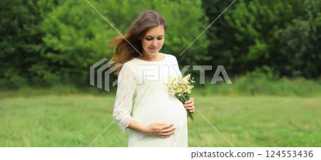 Pregnancy, maternity, happy young pregnant woman holding bouquet of flowers standing in summer park Pregnancy, maternity, happy young pregnant woman holding bouquet of flowers standing in summer park 124553436