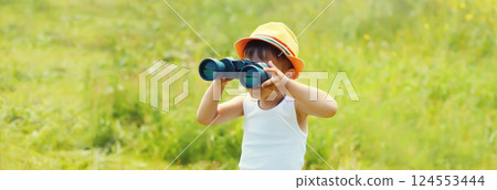 Little boy child looking through binoculars outdoors on summer day Little boy child looking through binoculars outdoors on summer day 124553444