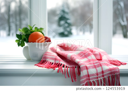 warm scarf lies on the windowsill of the house against the backdrop of winter weather. 124553919