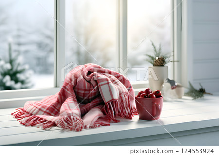 warm scarf lies on the windowsill of the house against the backdrop of winter weather 124553924