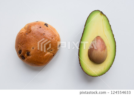 Chocolate chip bun and sliced avocado on white background 124554633