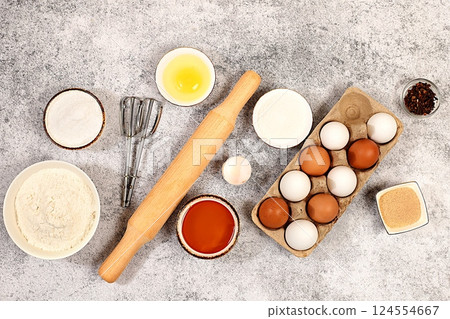 Kitchen background of food preparation.Culinary ingredients for making pie and bread,recipe with eggs,flour,sugar,honey,cinnamon,yeast and butter.Concept of modern bakery, 124554667