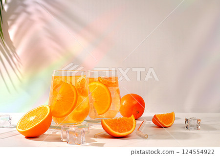 Modern still life with citrus fruits, Orange juice and oranges on elegant kitchen table with long hard shadows. minimal detox diet concept, summer vitamin drinks, selective focus, space for text Modern still life with citrus fruits, Orange juice and oranges on elegant kitchen table with long hard shadows. minimal detox diet concept, summer vitamin drinks, selective focus, space for text 124554922