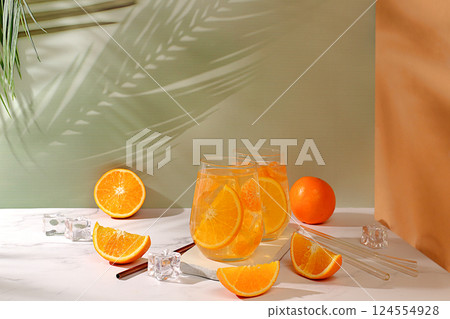Modern still life with citrus fruits, Orange juice and oranges on elegant kitchen table with long hard shadows. minimal detox diet concept, summer vitamin drinks, selective focus, space for text 124554928
