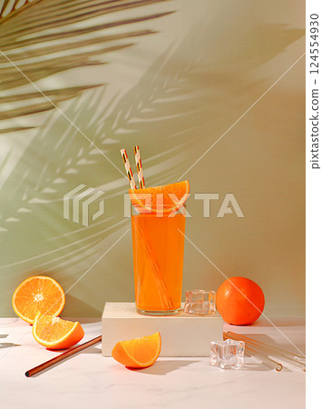 Modern still life with citrus fruits, Orange juice and oranges on elegant kitchen table with long hard shadows. minimal detox diet concept, summer vitamin drinks, selective focus, space for text 124554930