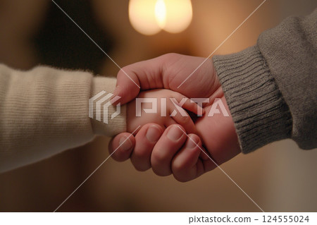 Close-up of a child's hand held by an adult in warm light. An intimate moment captured showing a child's hand held by a larger adult hand, symbolizing care and nurturing under soft, natural lighting. Close-up of a child's hand held by an adult in warm light. An intimate moment captured showing a child's hand held by a larger adult hand, symbolizing care and nurturing under soft, natural lighting. 124555024