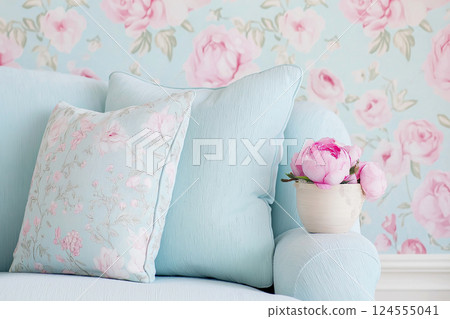 A collection of soft and textured cushions placed against a pastel floral wallpaper backdrop for an elegant interior setting. Bright colors and vintage decor complement each other beautifully. 124555041