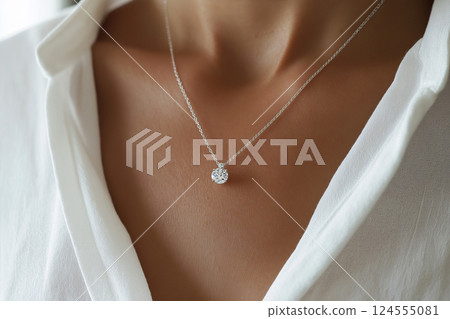 Elegant jewelry closeup featuring a diamond necklace on a delicate chain. Closeup of a diamond necklace on a neck emphasizes sophistication and beauty. Luxury jewelry, white gold and diamonds. 124555081