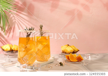 Detox diet and summer party concept. Cold homemade cocktail or lemonade with rosemary, orange, ice and pineapple on a sunny table, Refreshing summer diet drink recipe, restaurant menu, selective Detox diet and summer party concept. Cold homemade cocktail or lemonade with rosemary, orange, ice and pineapple on a sunny table, Refreshing summer diet drink recipe, restaurant menu, selective 124555303