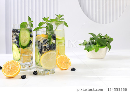 Detox diet and summer party concept. Cold homemade lemonade or cocktail with mint, lemon, cucumber and lime on a sunny table, Refreshing summer drink recipe, restaurant menu, selective approach Detox diet and summer party concept. Cold homemade lemonade or cocktail with mint, lemon, cucumber and lime on a sunny table, Refreshing summer drink recipe, restaurant menu, selective approach 124555366