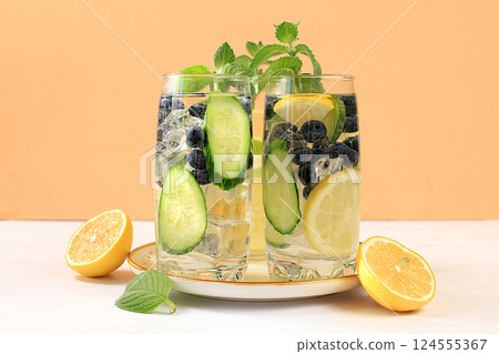 Cold homemade lemonade or cocktail with mint, lemon, cucumber and lime on a sunny table, Detox diet and summer party concept. Refreshing summer drink recipe, restaurant menu, selective approach Cold homemade lemonade or cocktail with mint, lemon, cucumber and lime on a sunny table, Detox diet and summer party concept. Refreshing summer drink recipe, restaurant menu, selective approach 124555367