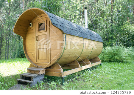 Round wooden barrel sauna in the forest. Healthy lifestyle 124555789