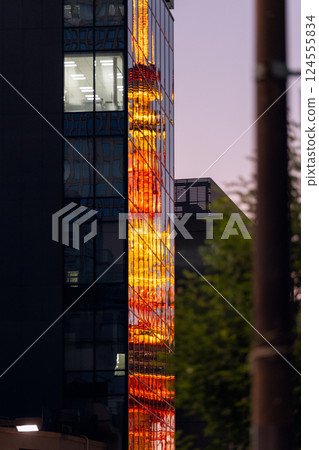 Tokyo Tower with night illumination reflecting in the glass facade of a skyscraper Tokyo Tower with night illumination reflecting in the glass facade of a skyscraper 124555834