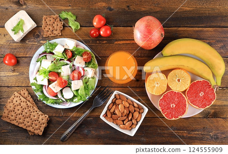 Healthy balanced food with dietary ingredients, vegetable salad with feta cheese and tropical fruits for weight loss, healthy lifestyle concept. Organic anti-virus products 124555909