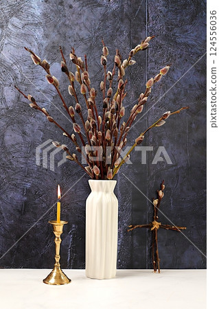 Religious banner. Delicate consecrated pussy willow flowers in vase and candle on concrete background, abstract spring floral arrangement. Easter card and still life, minimal holiday concept, home 124556036