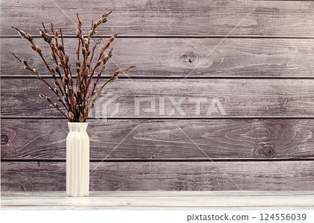 Delicate pussy willow flowers in vase on wooden background, abstract spring floral arrangement. Easter card and still life, minimal holiday concept, religious banner, home interior, selective focus 124556039