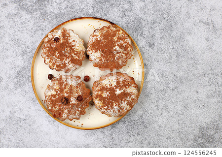 Chocolate muffins with nutmeg and cinnamon on a wooden background, cozy breakfast concept, advertising for a cafe or bakery, delicious dessert, selective focus 124556245