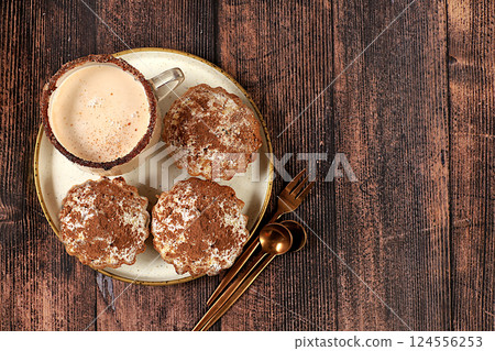 Delicious chocolate muffins with cranberries and milk drink eggnog with cocoa on a wooden table. Advertising card or menu for a cafe, restaurant. Concept of a modern bakery, selective focus Delicious chocolate muffins with cranberries and milk drink eggnog with cocoa on a wooden table. Advertising card or menu for a cafe, restaurant. Concept of a modern bakery, selective focus 124556253