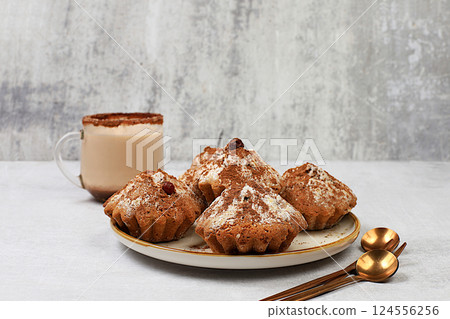 Delicious chocolate muffins with cranberries and milk drink eggnog with cocoa on a gray kitchen table. Advertising card or menu for a cafe, restaurant. Concept of a modern bakery, selective focus Delicious chocolate muffins with cranberries and milk drink eggnog with cocoa on a gray kitchen table. Advertising card or menu for a cafe, restaurant. Concept of a modern bakery, selective focus 124556256