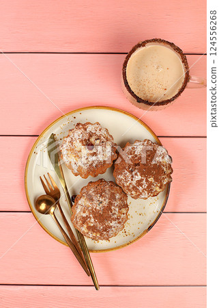 Chocolate muffins with nutmeg and cinnamon eggnog on a wooden background, cozy breakfast concept, advertising for a cafe or bakery. Warming egg drink in cold season with delicious dessert, selective Chocolate muffins with nutmeg and cinnamon eggnog on a wooden background, cozy breakfast concept, advertising for a cafe or bakery. Warming egg drink in cold season with delicious dessert, selective 124556268