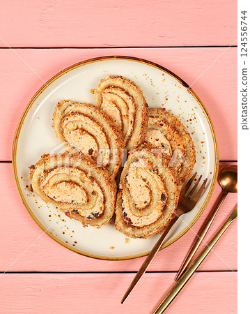 Homemade delicious dessert, biscuit or roll with sweet jam, cream, nuts and cinnamon filling. Modern bakery concept, festive treat and advertising for cafe and restaurant, selective focus 124556744