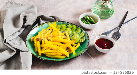 Appetizing French fries and cucumber slices on a plate on the table web banner Appetizing French fries and cucumber slices on a plate on the table web banner 124556829