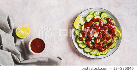 Delicious cucumbers with chili pepper and lime on a plate on the table top view web banner 124556846