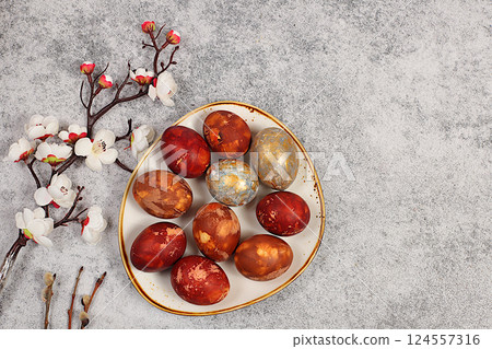 Marble Easter eggs painted with onion peel, hibiscus tea and pink matcha with sakura branches, Easter celebration concept, Easter dish ideas for home cooking. 124557316