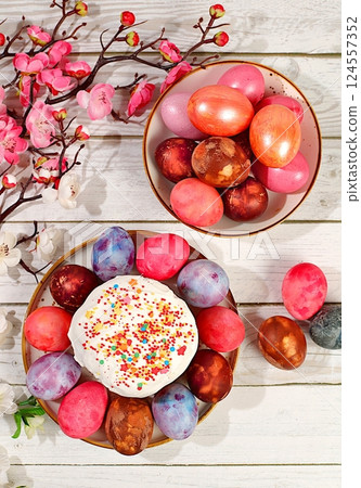 Traditional kulich and marbled Easter eggs painted with onion peel, hibiscus tea and pink matcha with sakura branches, Easter celebration concept, Easter dish ideas for home cooking. Traditional kulich and marbled Easter eggs painted with onion peel, hibiscus tea and pink matcha with sakura branches, Easter celebration concept, Easter dish ideas for home cooking. 124557352