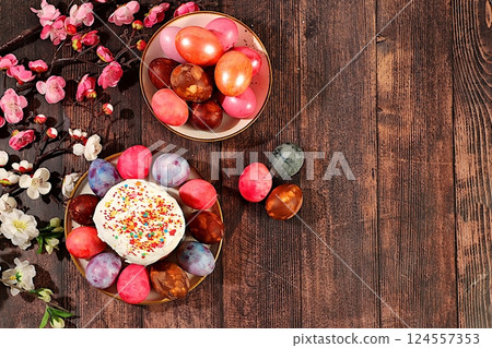 Traditional kulich and marbled Easter eggs painted with onion peel, hibiscus tea and pink matcha with sakura branches, Easter celebration concept, Easter dish ideas for home cooking. Traditional kulich and marbled Easter eggs painted with onion peel, hibiscus tea and pink matcha with sakura branches, Easter celebration concept, Easter dish ideas for home cooking. 124557353