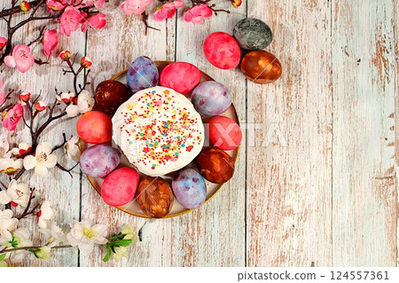 Easter celebration concept, traditional kulich and marble Easter eggs painted with onion peel, hibiscus tea and pink matcha with sakura branches, ideas for homemade Easter dishes. Easter celebration concept, traditional kulich and marble Easter eggs painted with onion peel, hibiscus tea and pink matcha with sakura branches, ideas for homemade Easter dishes. 124557361