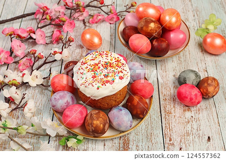 Traditional kulich and marbled Easter eggs painted with onion peel, hibiscus tea and pink matcha with sakura branches, Easter celebration concept, Easter dish ideas for home cooking. Traditional kulich and marbled Easter eggs painted with onion peel, hibiscus tea and pink matcha with sakura branches, Easter celebration concept, Easter dish ideas for home cooking. 124557362