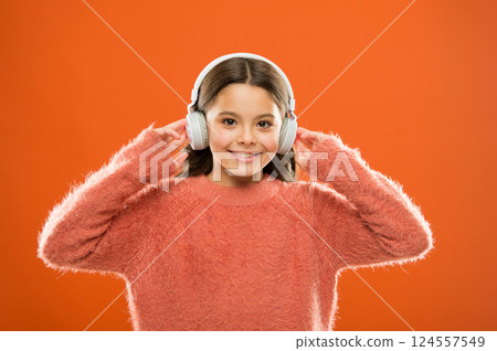 Delivering sound right to her ears with headphones. Small child listening to music in wireless headphones. Little girl wearing modern headphones. Cute kid enjoying stereo sound in headphones Delivering sound right to her ears with headphones. Small child listening to music in wireless headphones. Little girl wearing modern headphones. Cute kid enjoying stereo sound in headphones 124557549