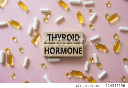 Thyroid Hormone symbol. Concept word Thyroid Hormone on wooden blocks. Beautiful pink background with pills. Medicine and Thyroid Hormone concept. Copy space Thyroid Hormone symbol. Concept word Thyroid Hormone on wooden blocks. Beautiful pink background with pills. Medicine and Thyroid Hormone concept. Copy space 124557596