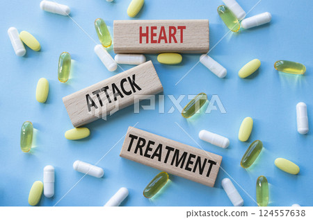 Heart Attack Treatment symbol. Concept word Heart Attack Treatment on wooden blocks. Beautiful blue background with pills. Medicine and Heart Attack Treatment concept. Copy space 124557638