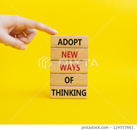 Adopt new ways of thinking symbol. Wooden blocks with words Adopt new ways of thinking. Businessman hand. Beautiful yellow background. Business and Adopt new ways of thinking concept. Copy space. 124557661