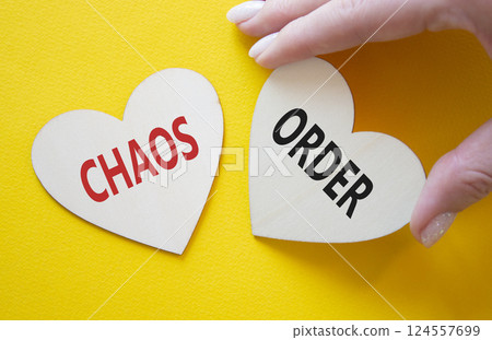 Chaos or Order symbol. Concept word Chaos or Order on wooden hearts. Businessman hand. Beautiful white background. Business and Chaos or Order concept. Copy space 124557699