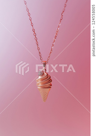 Elegant rose gold ice cream cone necklace on a soft pink background. Rose gold ice cream cone jewelry pendant. Sweets and fast fashion concept. Rip diet, creative jewelry. Summer vibes, holidays. 124558005