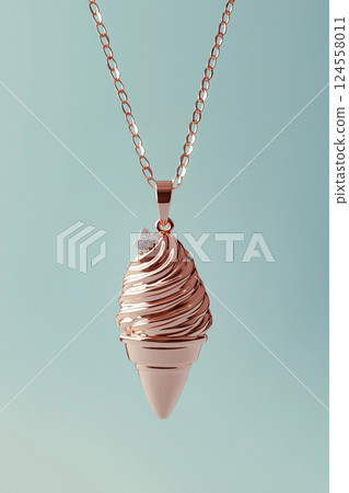 Elegant rose gold ice cream cone necklace on a soft pink background. Rose gold ice cream cone jewelry pendant. Sweets and fast fashion concept. Rip diet, creative jewelry. Summer vibes, holidays. 124558011