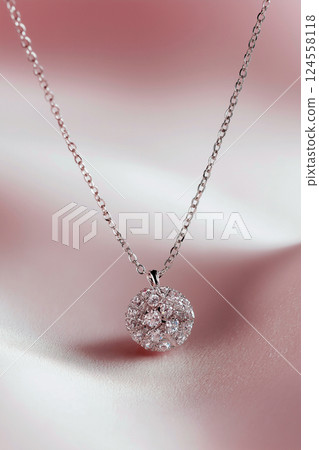 A stylish silver necklace featuring a ball-shaped pendant delicately hanging from a subtle chain. Ideal for both casual and formal occasions, it exudes simplicity and sophistication. 124558118