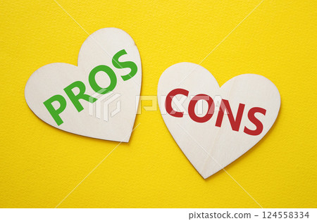 Pros vs Cons symbol. Concept word Pros vs Cons on wooden hearts. Beautiful yellow background. Business and Pros vs Cons concept. Copy space 124558334
