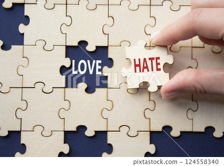 Love vs Hate symbol. Concept word Love vs Hate on wooden puzzle. Businessman hand. Beautiful deep blue background. Business and Love vs Hate concept. Copy space Love vs Hate symbol. Concept word Love vs Hate on wooden puzzle. Businessman hand. Beautiful deep blue background. Business and Love vs Hate concept. Copy space 124558340